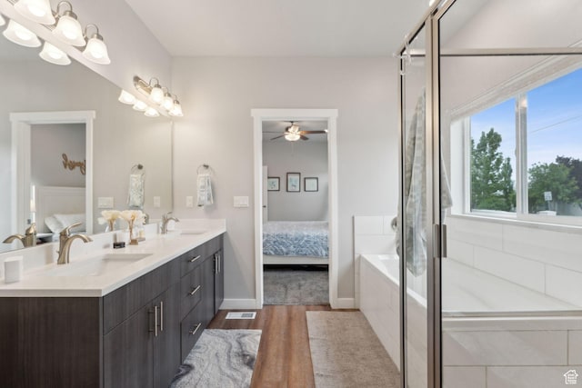 ensuite bathroom with wood finished floors, a ceiling fan, a bath, double vanity, and a shower with door