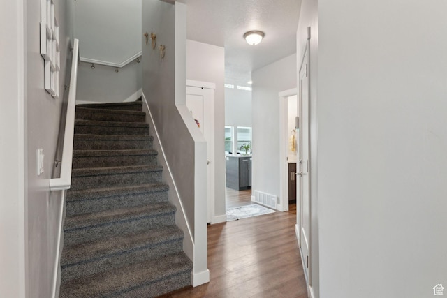 stairway with wood finished floors and baseboards