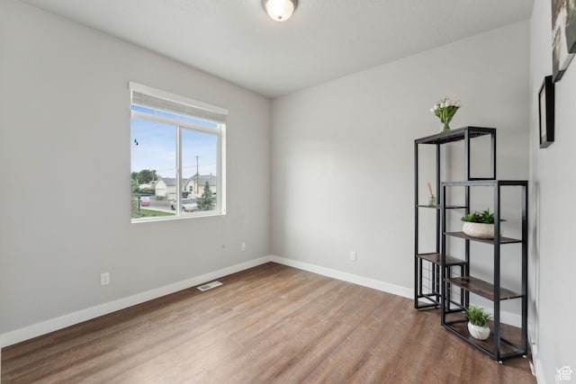 empty room with wood finished floors and baseboards