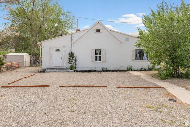 view of front facade featuring stucco siding and fence