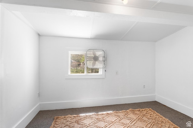spare room with dark colored carpet and baseboards
