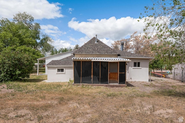back of house featuring a sunroom, a shingled roof, and fence