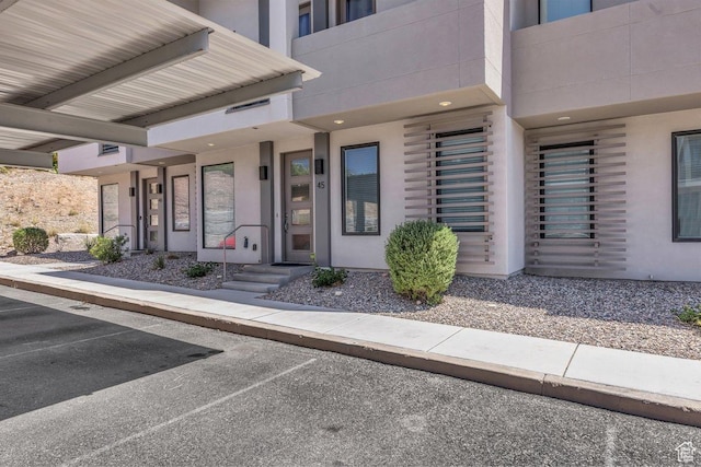 doorway to property featuring stucco siding