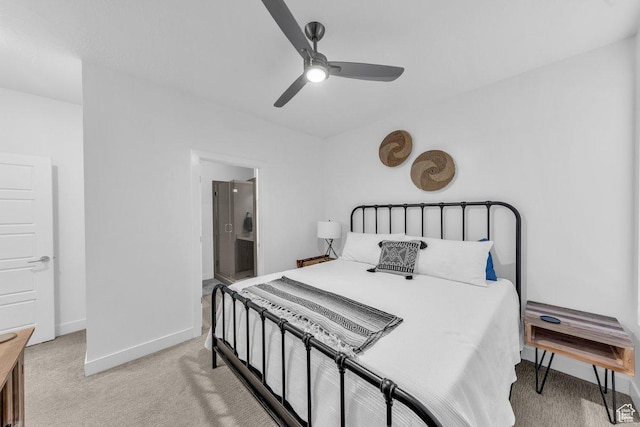 bedroom featuring light colored carpet, baseboards, ceiling fan, and connected bathroom
