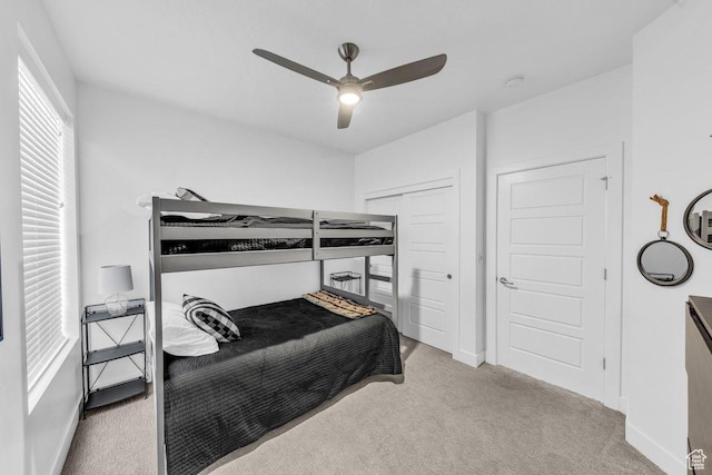 bedroom featuring carpet floors, baseboards, a ceiling fan, and a closet