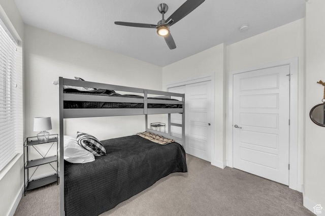 carpeted bedroom with baseboards, a ceiling fan, and a closet
