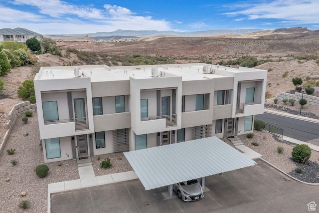 view of building exterior with a mountain view and a parking lot