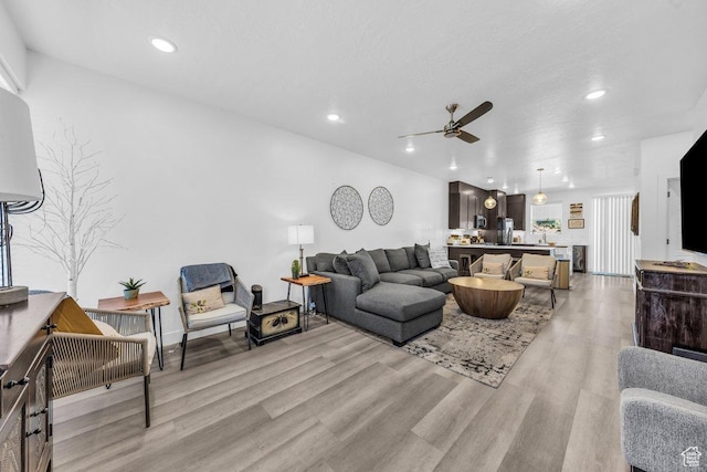 living room featuring a ceiling fan, light wood-style floors, and recessed lighting