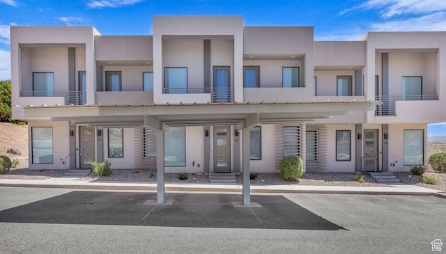townhome / multi-family property featuring stucco siding and covered parking