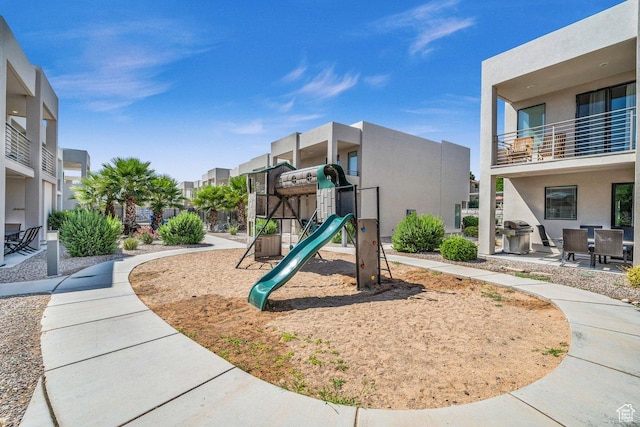 community jungle gym with a residential view and a patio