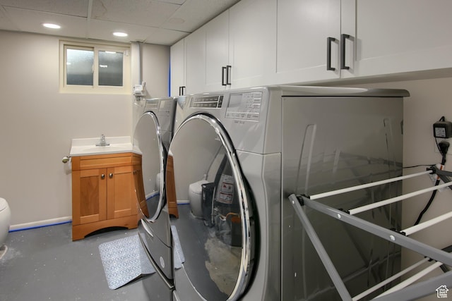 laundry area with washing machine and clothes dryer, recessed lighting, and a sink