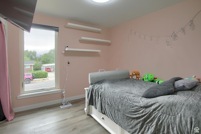 bedroom with baseboards and light wood finished floors