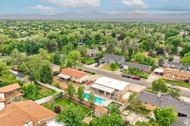 aerial perspective of suburban area with a mountainous background and a pool area