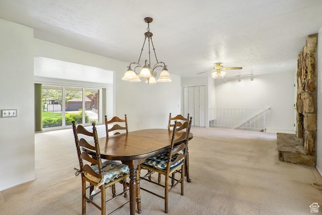 dining room featuring light carpet and a chandelier