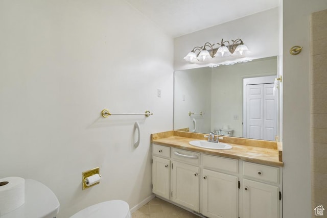 bathroom featuring toilet, vanity, tile patterned flooring, and baseboards