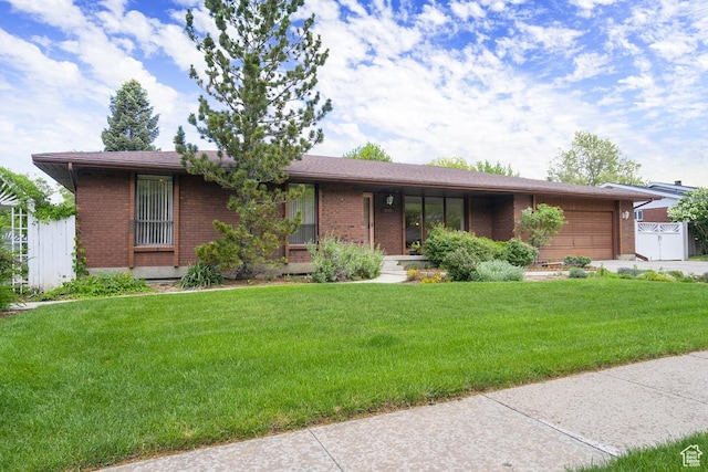 single story home featuring brick siding, a garage, a front yard, and a porch