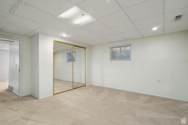 unfurnished bedroom featuring carpet flooring, a drop ceiling, recessed lighting, a closet, and baseboards