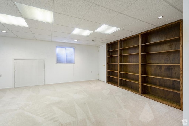 carpeted spare room with built in features, a paneled ceiling, and recessed lighting