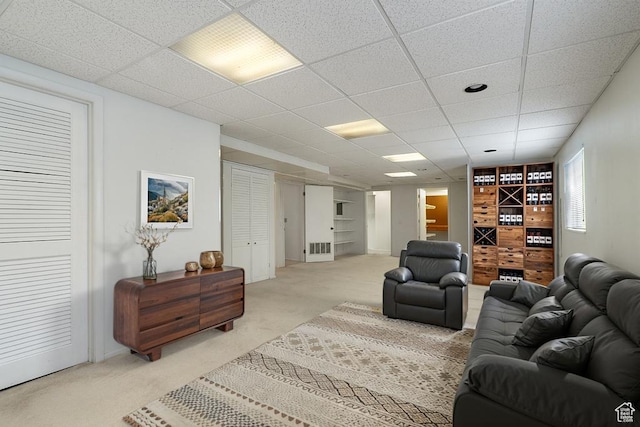 living area with light carpet and a drop ceiling