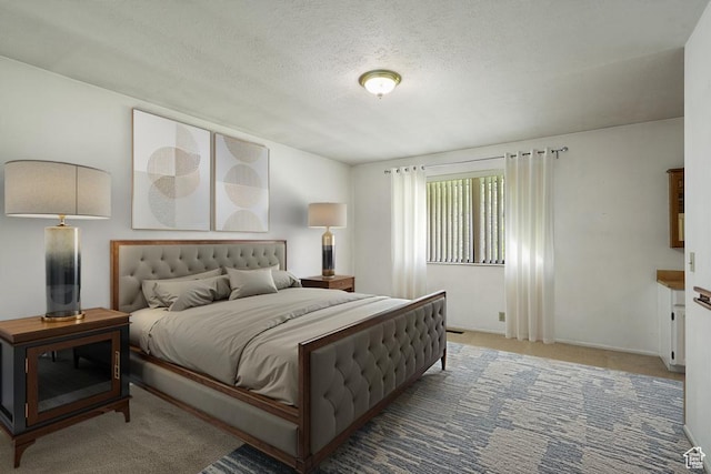 carpeted bedroom featuring a textured ceiling and baseboards