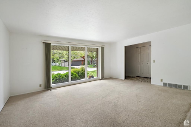 carpeted spare room featuring baseboards