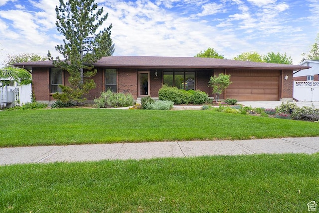 ranch-style house with a garage, brick siding, and a front yard