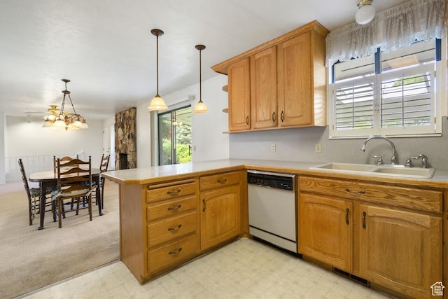 kitchen featuring dishwasher, a sink, light countertops, and a peninsula