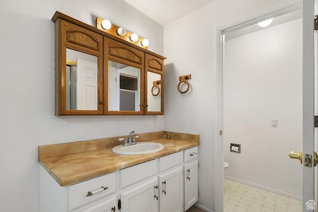 bathroom featuring tile patterned floors, vanity, toilet, and baseboards