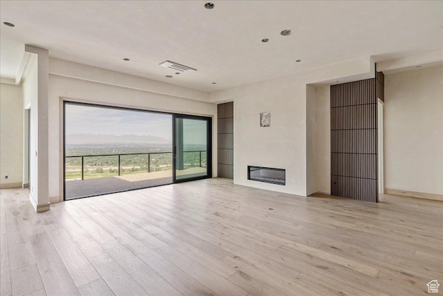 6078 S Heughs Canyon Way, Holladay, UT 84121 - unfurnished living room featuring light wood-style flooring, baseboards, a glass covered fireplace, and recessed lighting