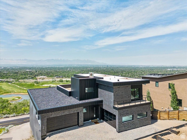 6078 S Heughs Canyon Way, Holladay, UT 84121 - view of front facade featuring a balcony, gravel driveway, and a water and mountain view