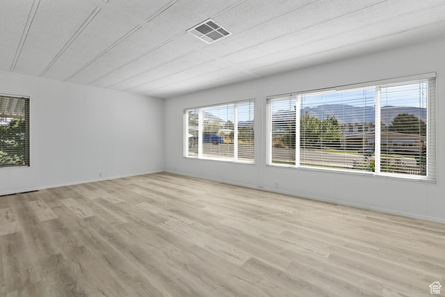 unfurnished room with light wood-style flooring and baseboards