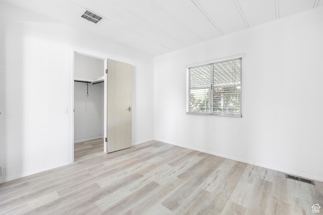 unfurnished bedroom with light wood-style flooring and a closet