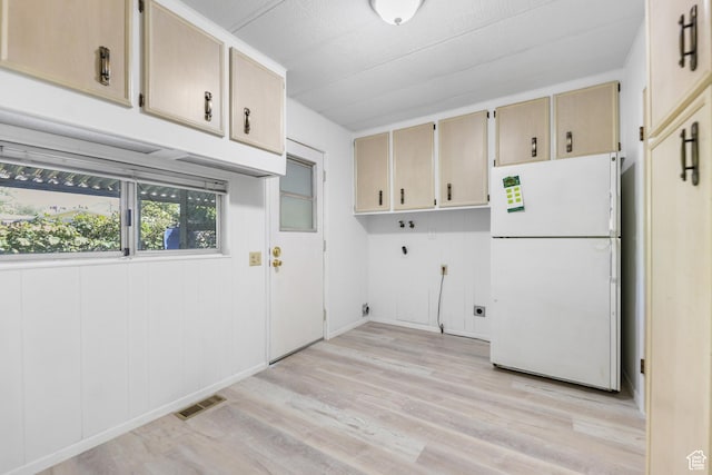 clothes washing area featuring cabinet space, electric dryer hookup, light wood-style floors, and hookup for a washing machine