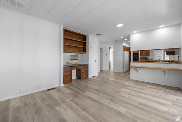 unfurnished living room with recessed lighting and light wood-type flooring