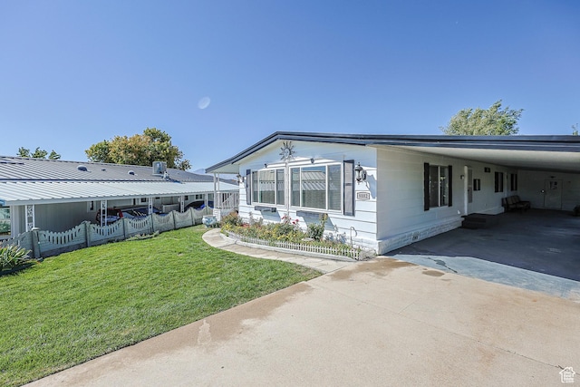 view of side of home featuring concrete driveway and a carport