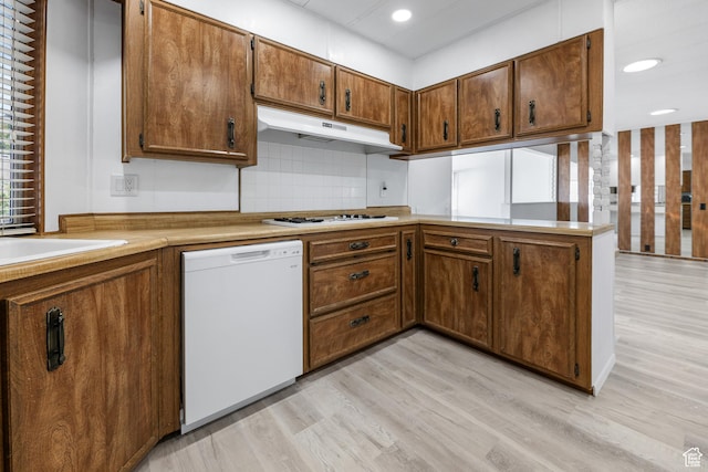 kitchen with white appliances, under cabinet range hood, backsplash, light wood finished floors, and recessed lighting