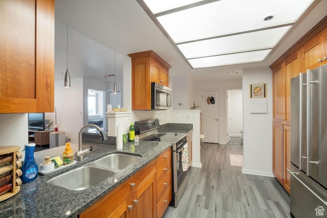 48 W Broadway Unit 1804N, Salt Lake City, UT 84101 - kitchen featuring stainless steel appliances, a sink, brown cabinets, light wood-type flooring, and dark stone countertops