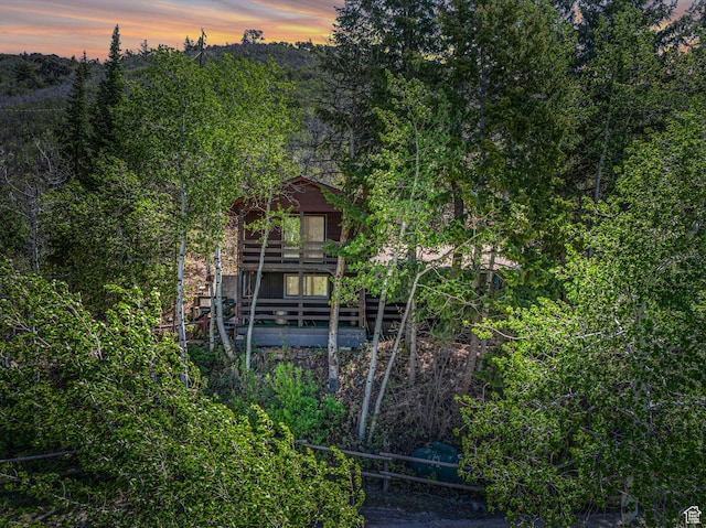 1456 E Weber Wild Rd, Oakley, UT 84055 - back of house at dusk featuring a wooded view