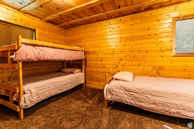 bedroom with wooden ceiling, carpet flooring, and wood walls
