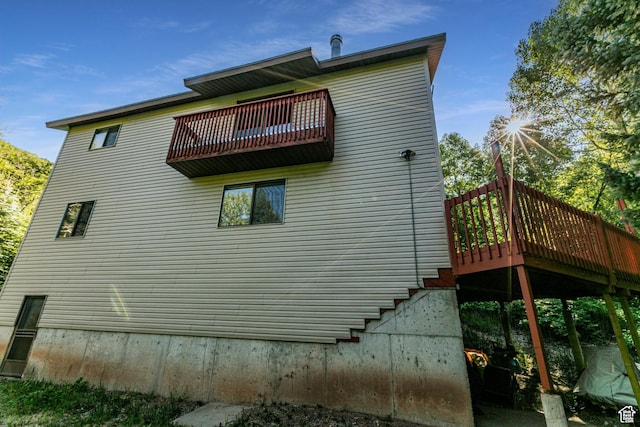 view of side of property featuring a balcony and a deck