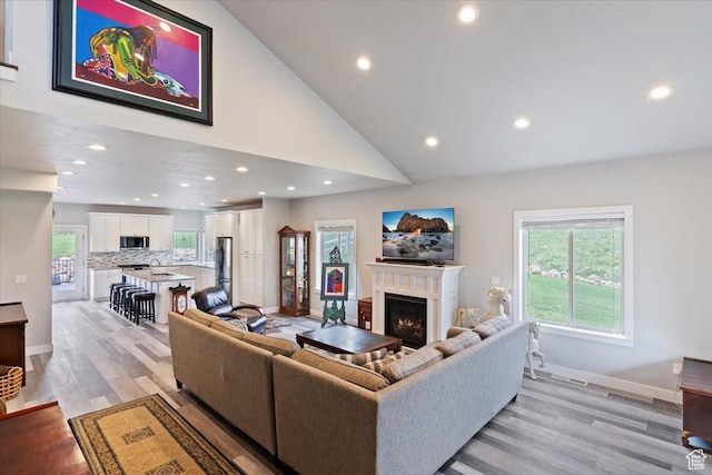 4026 E 4325 N, Eden, UT 84310 - living room with a lit fireplace, recessed lighting, light wood-style flooring, healthy amount of natural light, and high vaulted ceiling