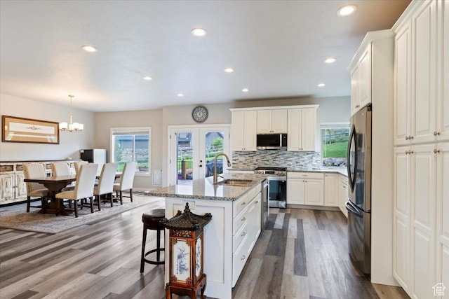 4026 E 4325 N, Eden, UT 84310 - kitchen with a sink, appliances with stainless steel finishes, wood finished floors, light stone countertops, and a kitchen bar