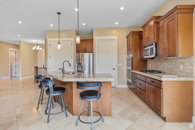 kitchen with appliances with stainless steel finishes, a sink, brown cabinets, tasteful backsplash, and recessed lighting