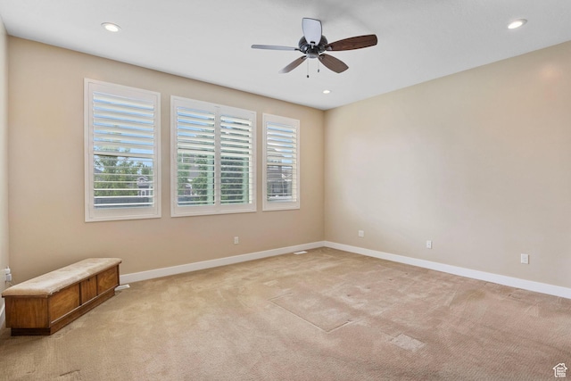 unfurnished room featuring light colored carpet, a ceiling fan, baseboards, and recessed lighting