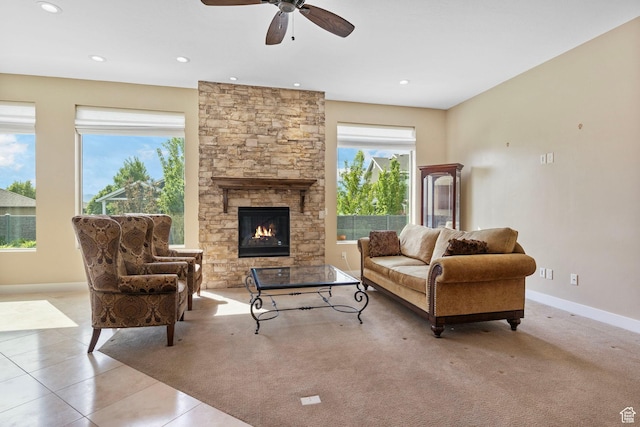 tiled living area featuring a fireplace, a ceiling fan, baseboards, and recessed lighting