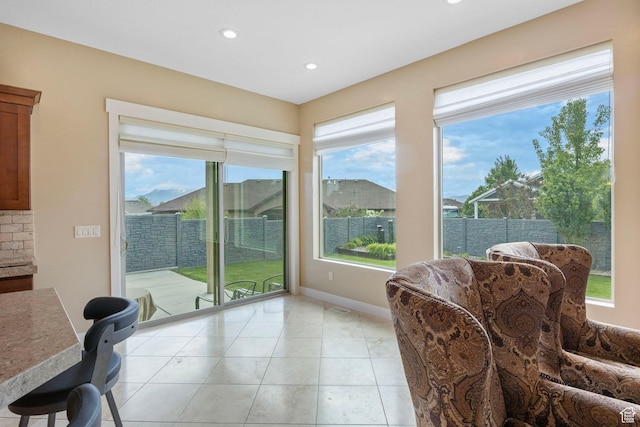 sitting room featuring plenty of natural light, recessed lighting, light tile patterned floors, and baseboards