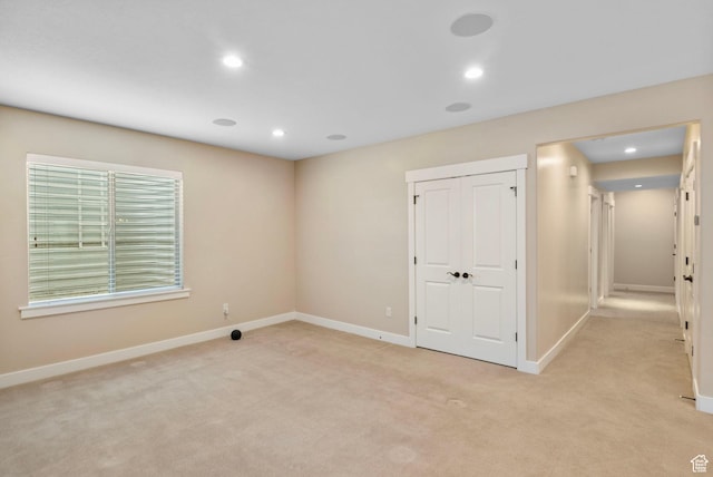 spare room with light carpet, baseboards, and recessed lighting