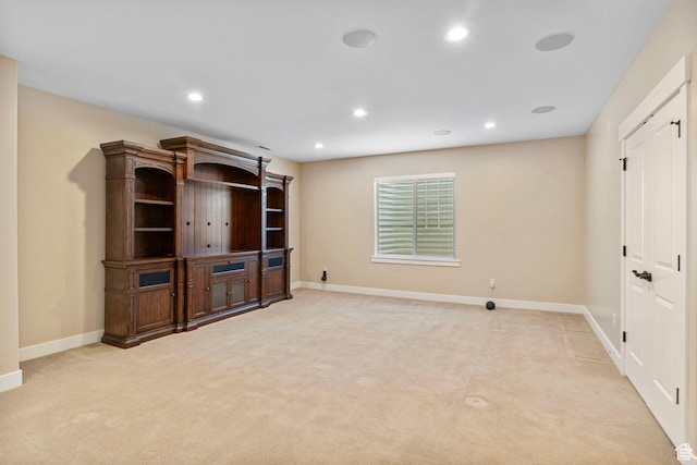 unfurnished living room with light colored carpet, recessed lighting, and baseboards