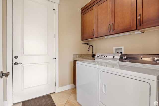 clothes washing area featuring cabinet space, independent washer and dryer, light tile patterned floors, and baseboards