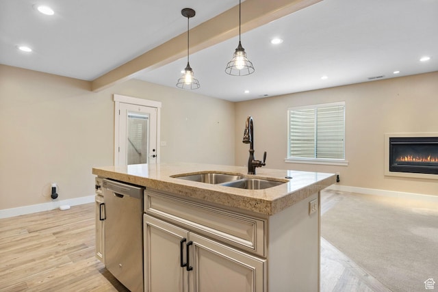 kitchen featuring dishwasher, baseboards, open floor plan, a glass covered fireplace, and hanging light fixtures